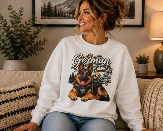 A woman sitting on a couch wearing a white crewneck sweatshirt with a large graphic of a German Shepherd dog and the words 'German Shepherd'.
